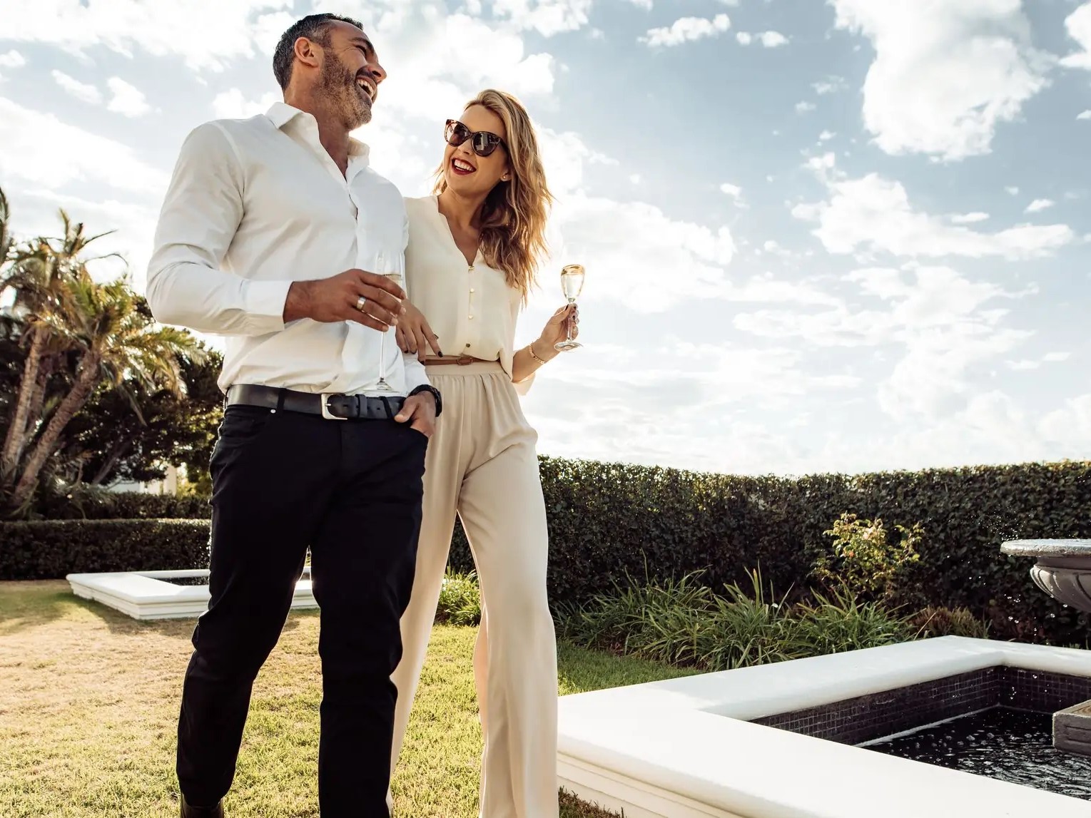 couple-walking-together-with-wine-in-lawn-of-their-house-man-and-woman